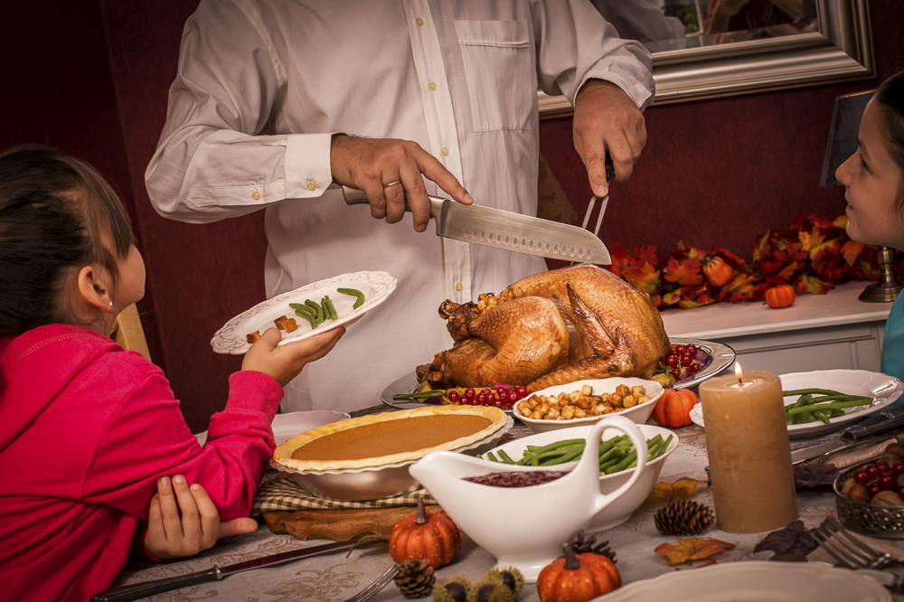 Mother cutting Thanksgiving turkey for kids