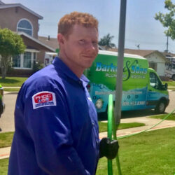 Barker and Sons technician posing in front of a service truck performing some drain cleaning on a customers home.