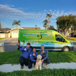 Barker and Sons team posing with a happy client and his dog.