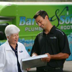 Barker and Sons technician going over the job details with a happy customer.