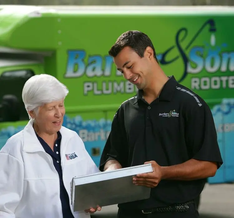 Barker and Sons technician going over the job details with a happy customer.