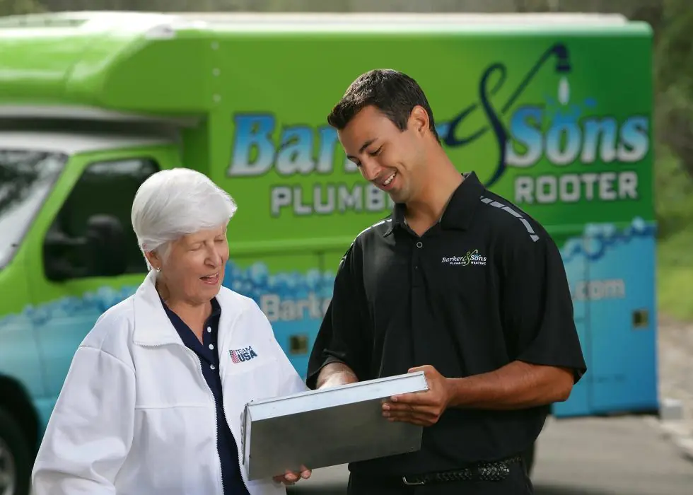 Barker and Sons technician going over the job details with a happy customer.