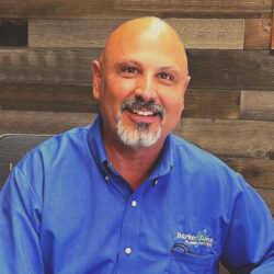 Mike Barker, the founder of Barker and Sons posing for a picture at work.