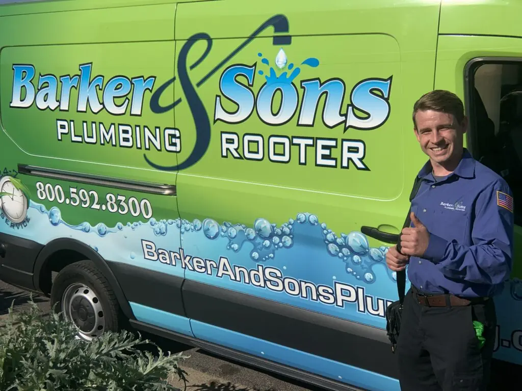 Barker and Sons technician posing in front of one of their service trucks