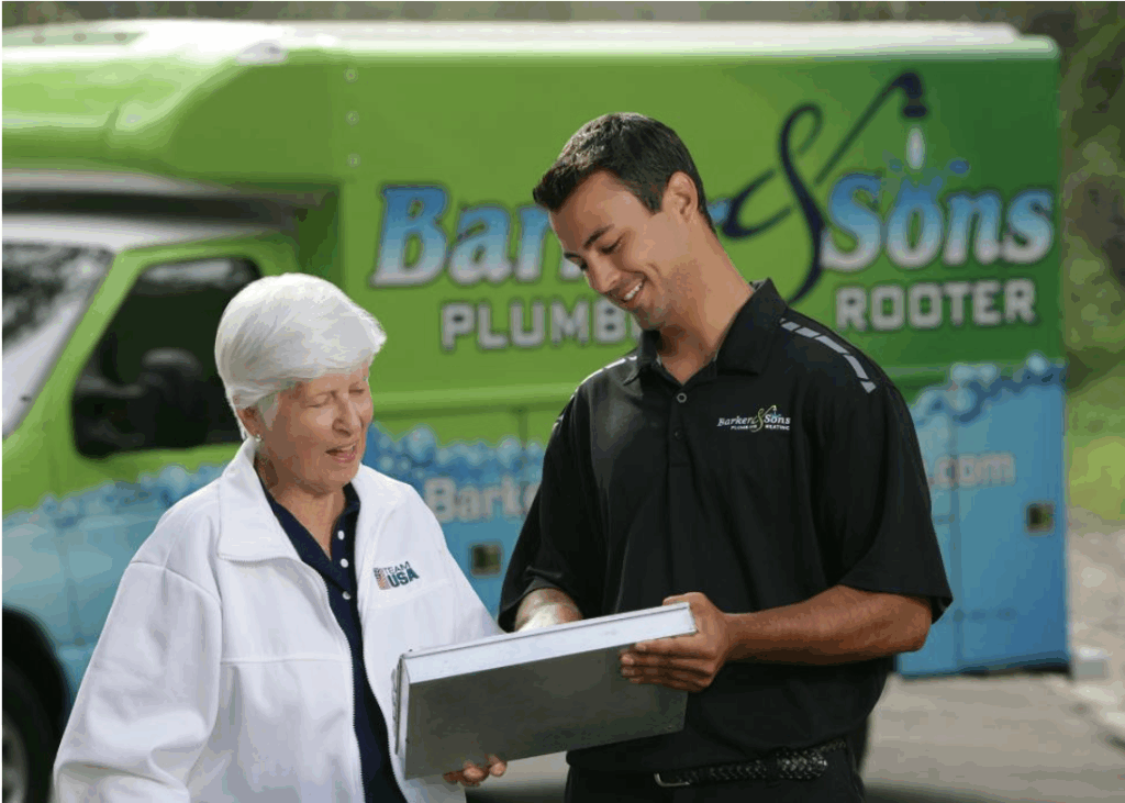 A plumber meets an older woman outside by a Bark & Sons Plumbing Rooter van and shows her paperwork to confirm her professional drain cleaning appointment.
